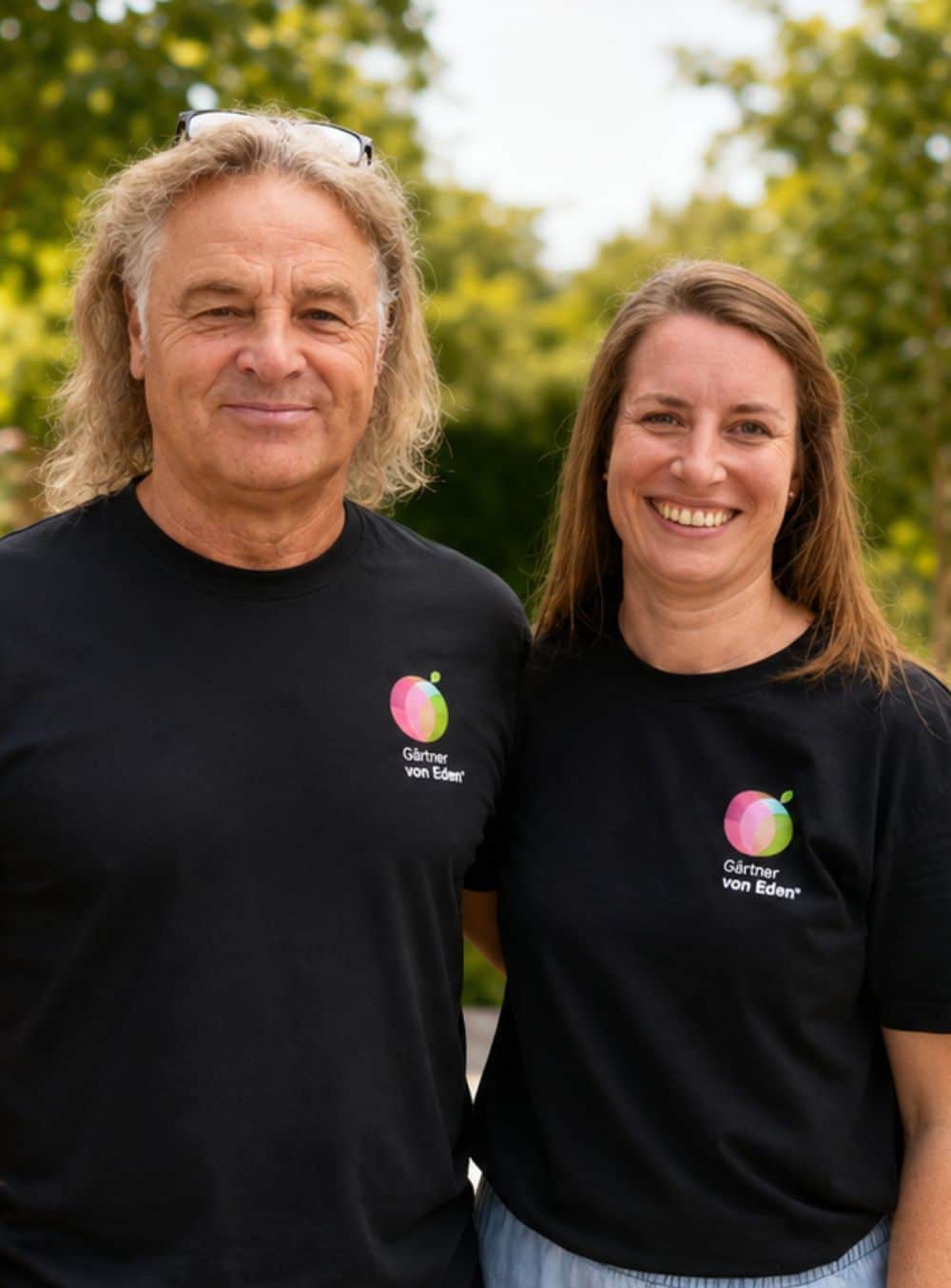 Michael und Christina Sieber_1000x1354px Michael Sieber und Christna Sieber-Ullrich lächeln in schwarzen PLANTA-Shirts vor einem modernen Haus mit Garten